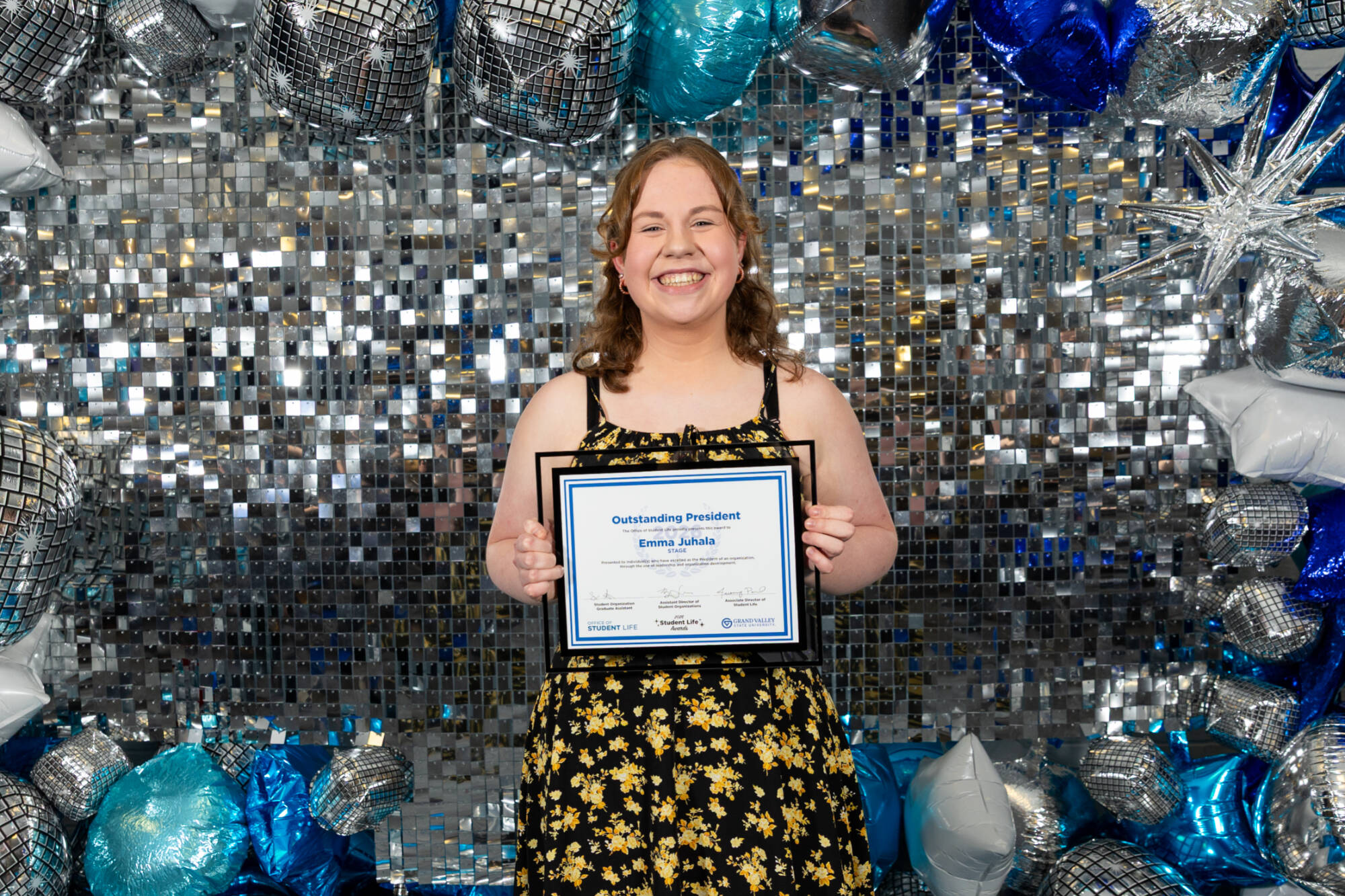 An individual holding up an award certificate
